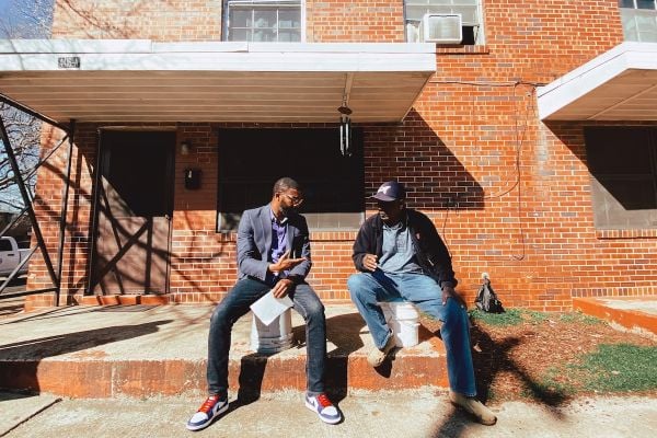 Mayor Woofin sits outside of a building with a resident of Birmingham